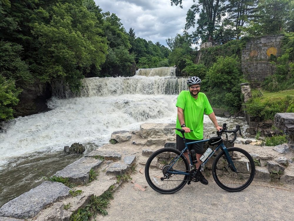 Me and my road bike in front of a rushing waterfall