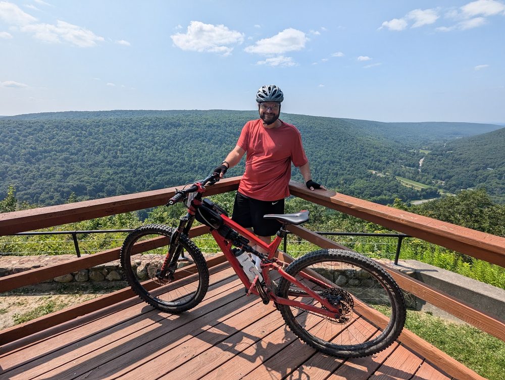 Me and my mountain bike on a lookout deck above a forested valley
